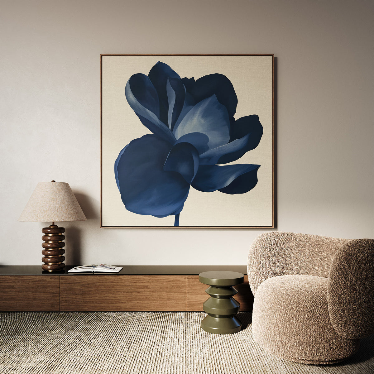 A modern living room featuring a beige textured armchair, olive green side table, wooden console, table lamp, and the large Midnight Bloom Canvas Art – Square displaying a dark blue flower on the wall.