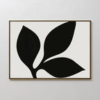 The Midnight Botanist Canvas Art showcases a bold black plant silhouette with three leaves on a white backdrop, framed in thin brown wood—an ideal choice for modern living room decor.