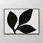 Midnight Botanist Canvas Art showcases a black abstract plant with three bold leaves on a white background, set in a slim black frame—ideal botanical wall art for modern living room decor.