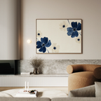 A modern living room with a beige sofa, marble accents, and minimalist decor featuring the Midnight Garden Canvas Art—a large abstract flower print in blue and cream—above a shelf with a vase of dried branches. The space feels softly lit and minimalistic.