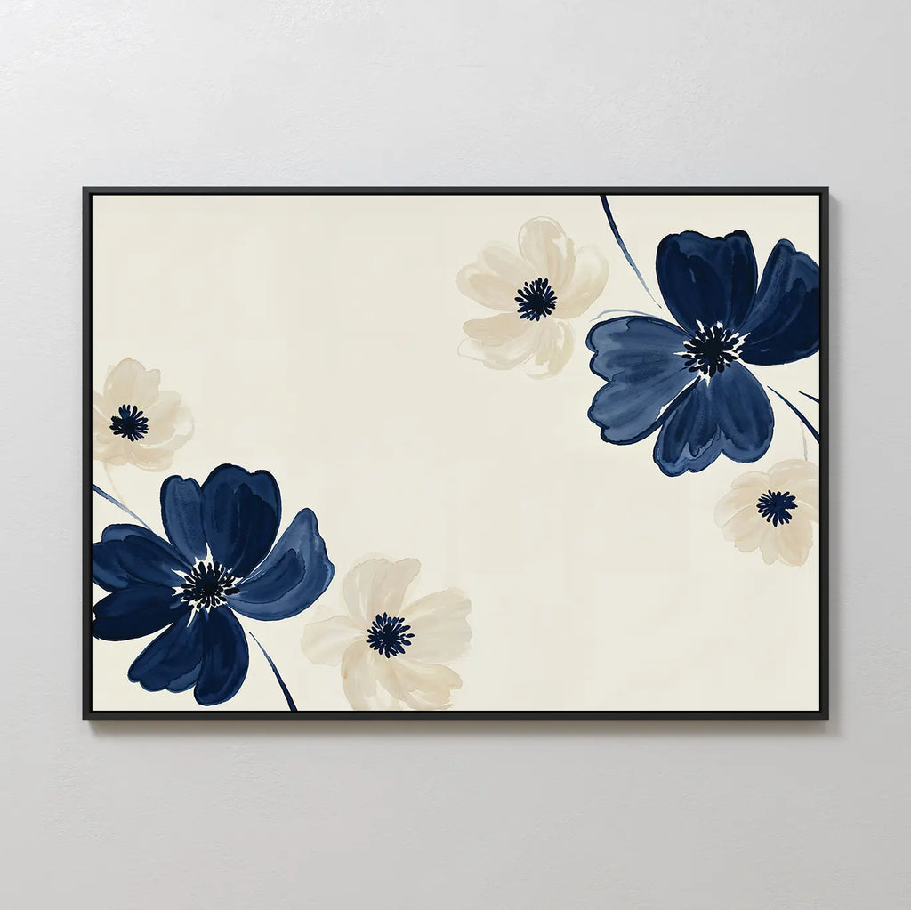 The Midnight Garden Canvas Art features large navy blue and light beige flowers with dark centers on a cream background, arranged diagonally for a striking modern look and framed in black.