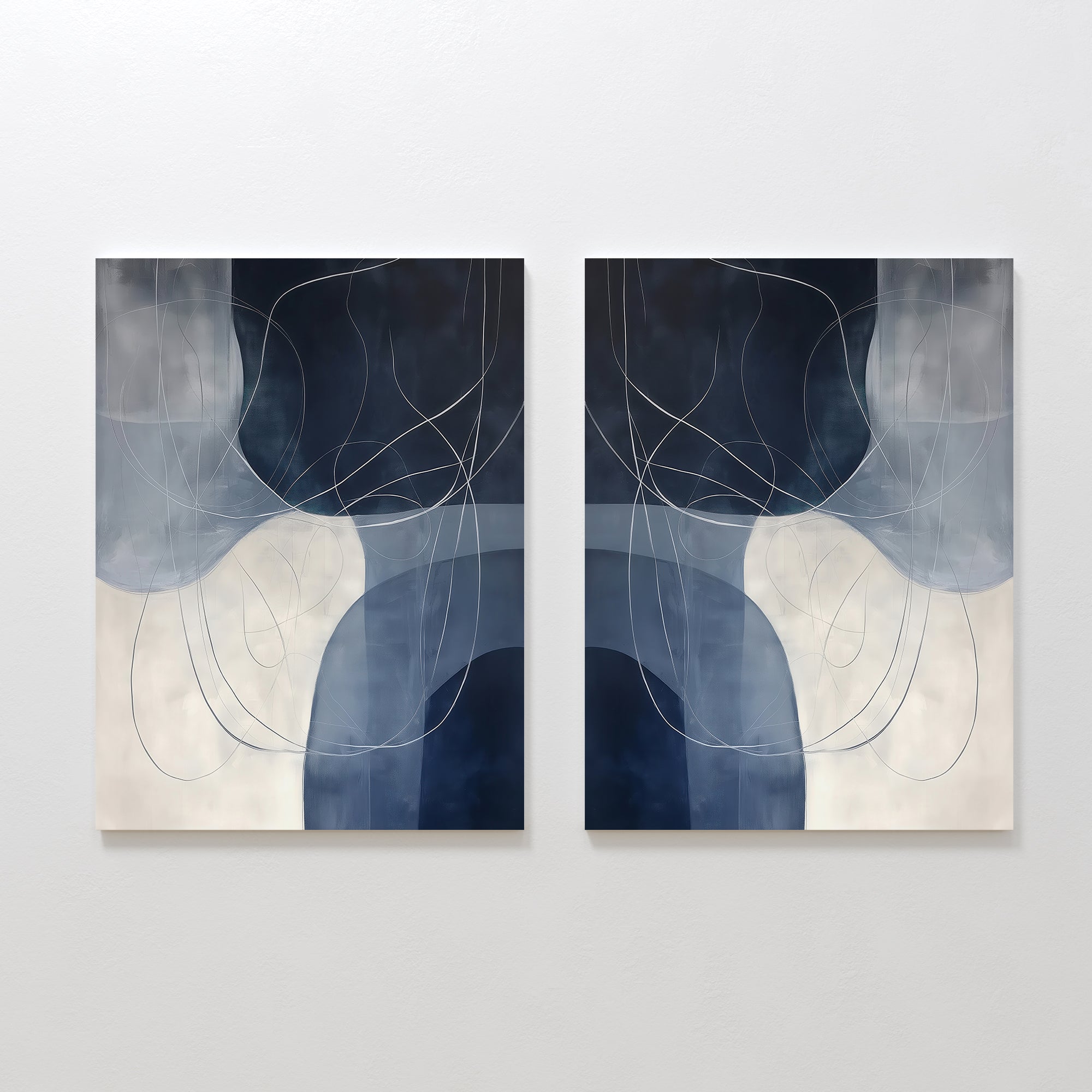 The "Midnight Lines Set of 2" features abstract minimalist wall art in cool blue, gray, and white tones, with curved shapes and looping lines forming a mirrored, symmetrical composition for a modern, elegant look.