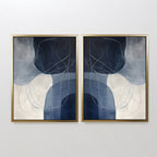 The Midnight Lines Set of 2 features abstract gold-framed paintings with overlapping blue, gray, and white shapes accented by thin curving lines, creating a mirrored modern design that adds elegance to any white wall.