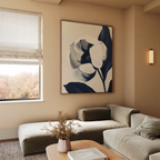 A modern living room with neutral tones features the Midnight Tulip Canvas Art on the wall, a beige sectional sofa, a wooden coffee table with a vase of dried flowers, and a window with a Roman shade.