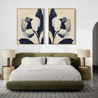 A modern bedroom with a low olive green bed, white bedding, matching round nightstands, two beige lamps, and the Midnight Tulip Set of 2 botanical wall art above the headboard on a white wall.