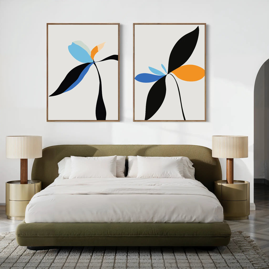 A modern bedroom with a green upholstered bed, beige nightstands with matching lamps, and the Minimal Flora Set of 2 wall art—abstract floral prints in blue, orange, and black—displayed above the bed for a stylish touch.