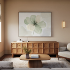 A modern living room with a wooden sideboard with geometric patterns, a coffee table, light sofa, beige rug, and the Mint Meadow Canvas Art in green and white tones adorning the wall.