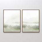 The Misty Forest Set of 2 features two framed prints side by side on a white wall, each with a minimalist, misty landscape in soft green and gray tones and faint tree outlines, evoking calm and serenity.