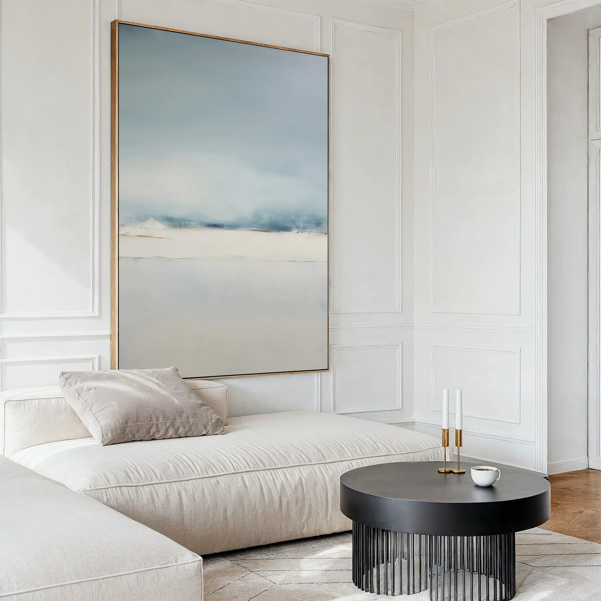 A modern living room with a cream chaise lounge, black round coffee table, cup, two candle holders, and the Misty Morning Canvas Art – Vertical on a white paneled wall creates a tranquil atmosphere inspired by Nordic Park.