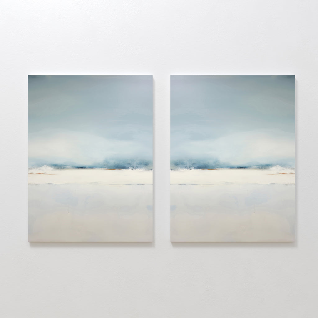 The Misty Morning Set of 2 features minimalist wall art in soft blue, white, and beige tones, hung side by side. Each piece evokes a tranquil mood with blurred horizontal landscapes reminiscent of a serene Nordic park.