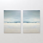 The Misty Morning Set of 2 features minimalist wall art in soft blue, white, and beige tones, hung side by side. Each piece evokes a tranquil mood with blurred horizontal landscapes reminiscent of a serene Nordic park.