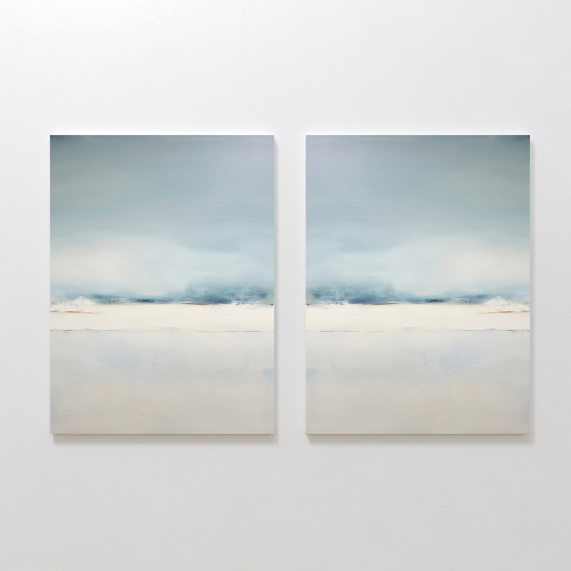 The Misty Morning Set of 2 features minimalist wall art in soft blue, white, and beige tones, hung side by side. Each piece evokes a tranquil mood with blurred horizontal landscapes reminiscent of a serene Nordic park.