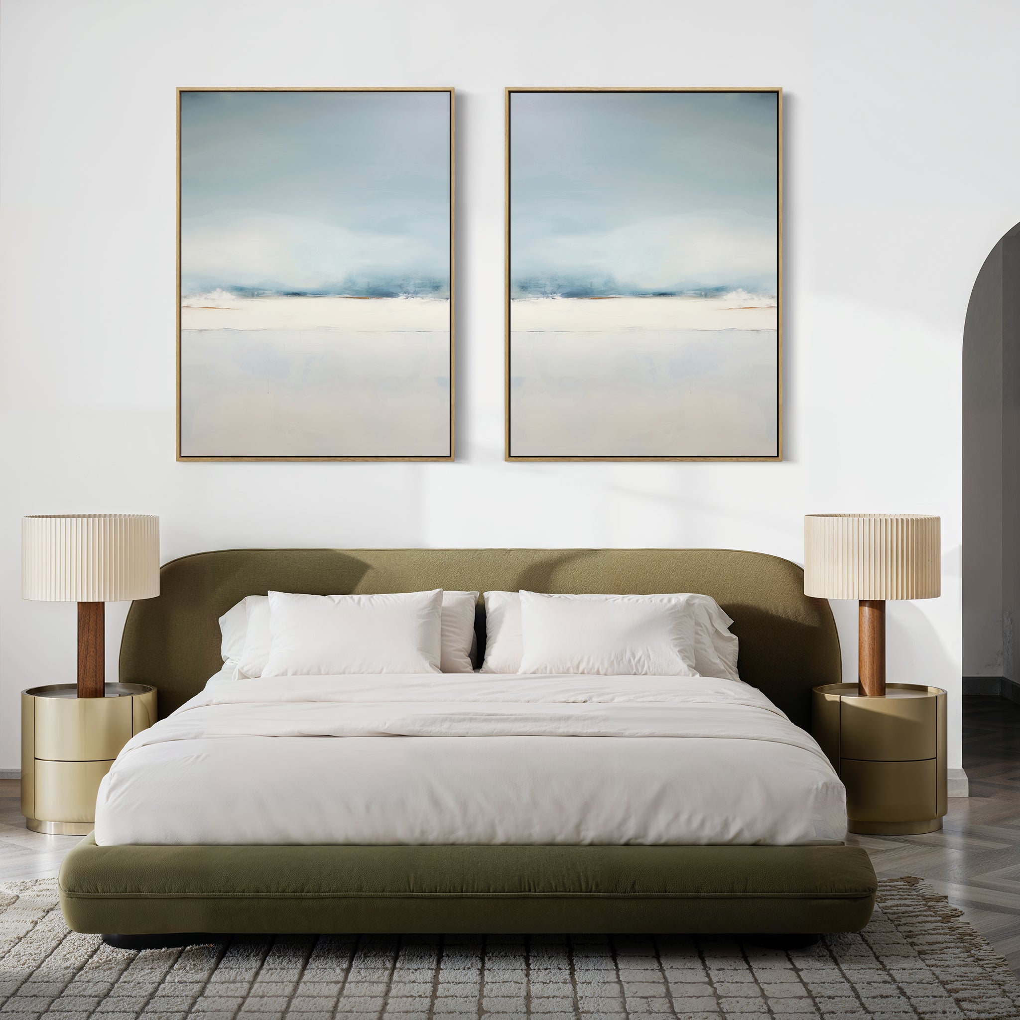 A modern bedroom with a green upholstered bed, white bedding, gold nightstands with pleated beige lamps, a gray textured rug, and the Misty Morning Set of 2 minimalist blue and white wall art above the bed creates a tranquil Nordic Park-inspired atmosphere.