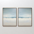 The Misty Morning Set of 2 features minimalist framed abstract paintings in soothing blue, white, and beige tones. Displayed side by side, they evoke the calm beauty of a Nordic park over water, creating a tranquil atmosphere in any space.