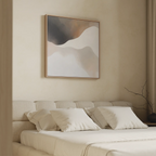 A modern bedroom features a beige bed with white pillows, highlighted by the Misty Silhouette Canvas Art in soft neutral tones above the headboard, while a bare branch on the bedside table enhances the calm, minimalist ambiance.