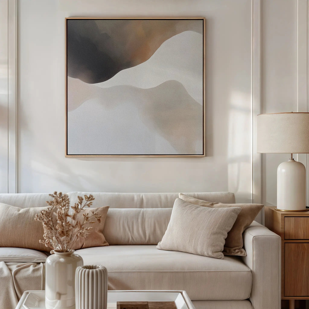 A minimalist living room with a beige sofa, neutral pillows, a side table topped with a ceramic lamp, dried flowers in a vase, and modern decor highlighted by the Misty Silhouette Canvas Art in earth tones on the wall.