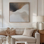 A minimalist living room with a beige sofa, neutral pillows, a side table topped with a ceramic lamp, dried flowers in a vase, and modern decor highlighted by the Misty Silhouette Canvas Art in earth tones on the wall.