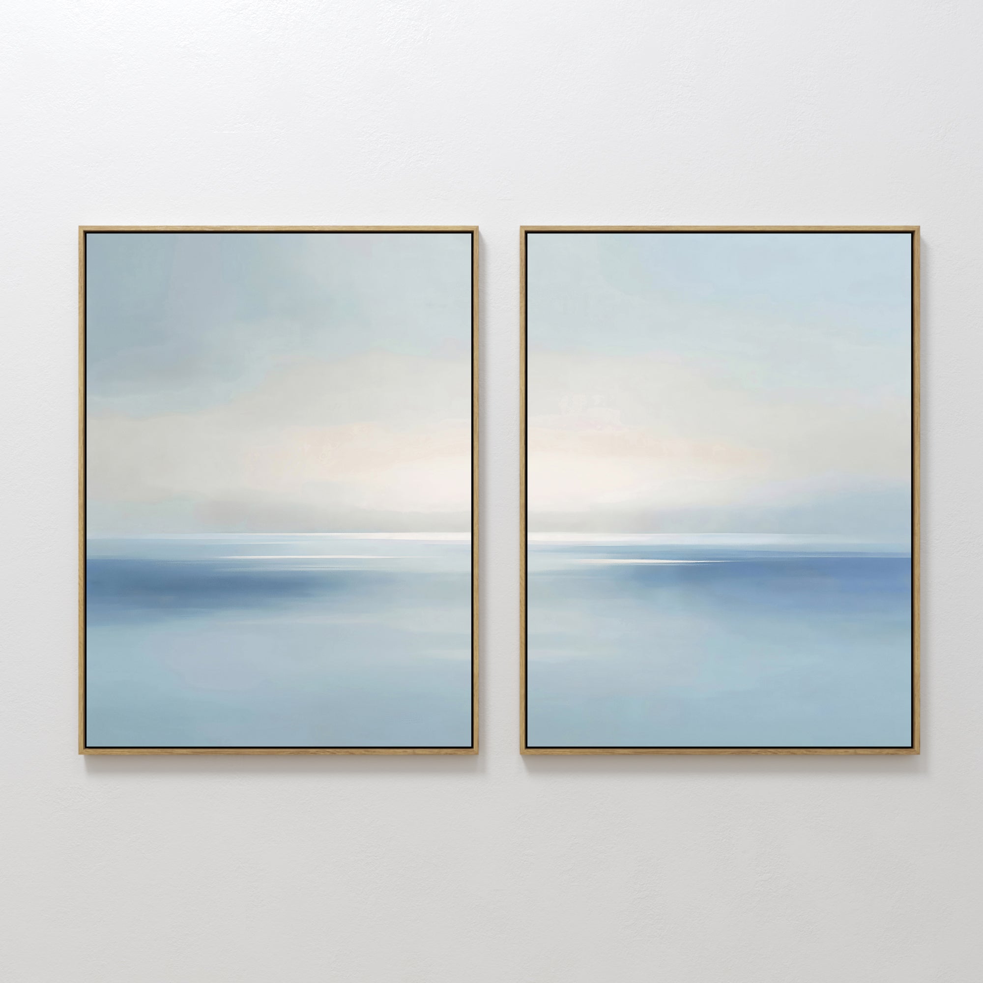 The Misty Waters Set of 2 features framed abstract art in soft blue and white tones, evoking a tranquil seascape. Hung side by side, these minimalist pieces blend gentle gradients to create a serene, peaceful atmosphere on any wall.