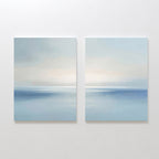 The Misty Waters Set of 2 features minimalist paintings of tranquil seascapes with soft blue tones, calm water, and hazy horizons beneath pastel skies—ideal serene wall art for your space.