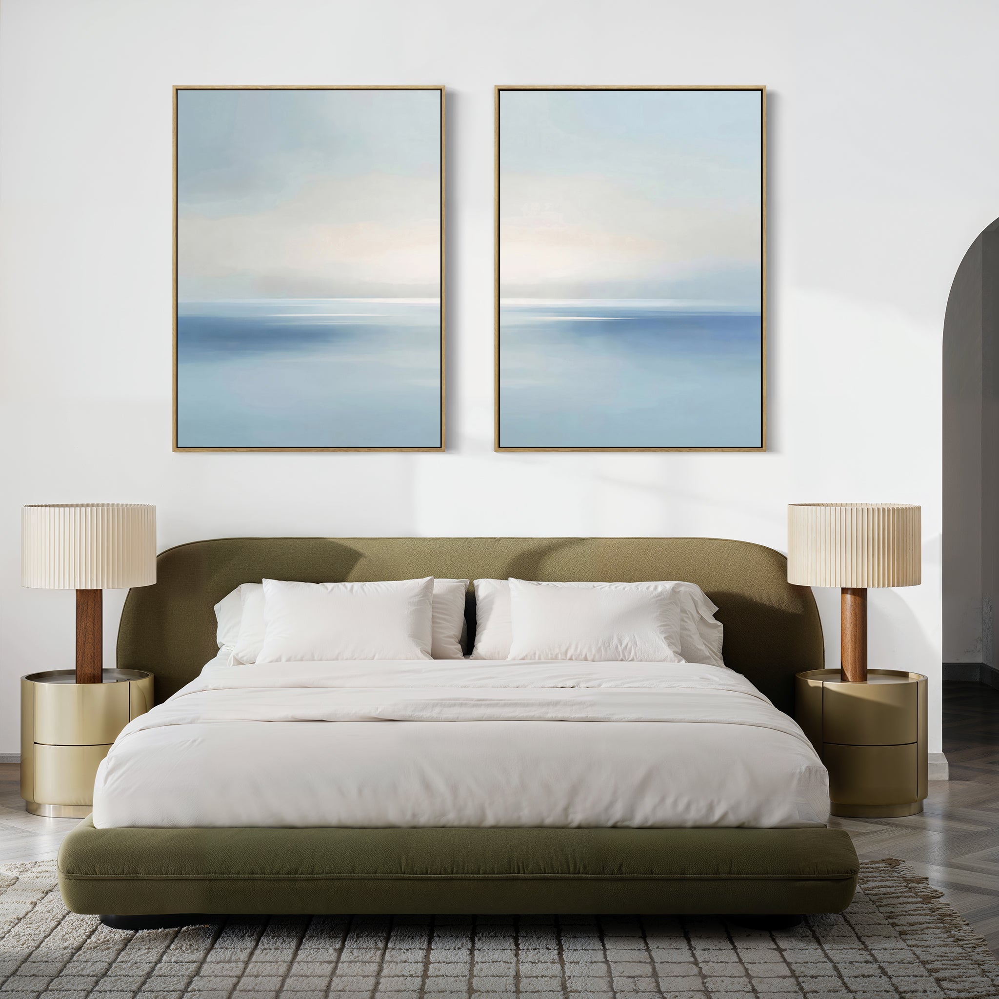 Minimalist bedroom with an olive green bed, white bedding, beige nightstands and lamps, and the Misty Waters Set of 2 serene blue and white artworks hung above the bed on a white wall.