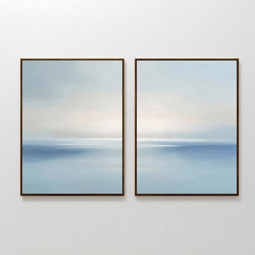 The Misty Waters Set of 2 features framed abstract paintings with soft blue and white tones, creating a serene seascape with a subtle horizon—perfect minimalist wall art for any modern space.