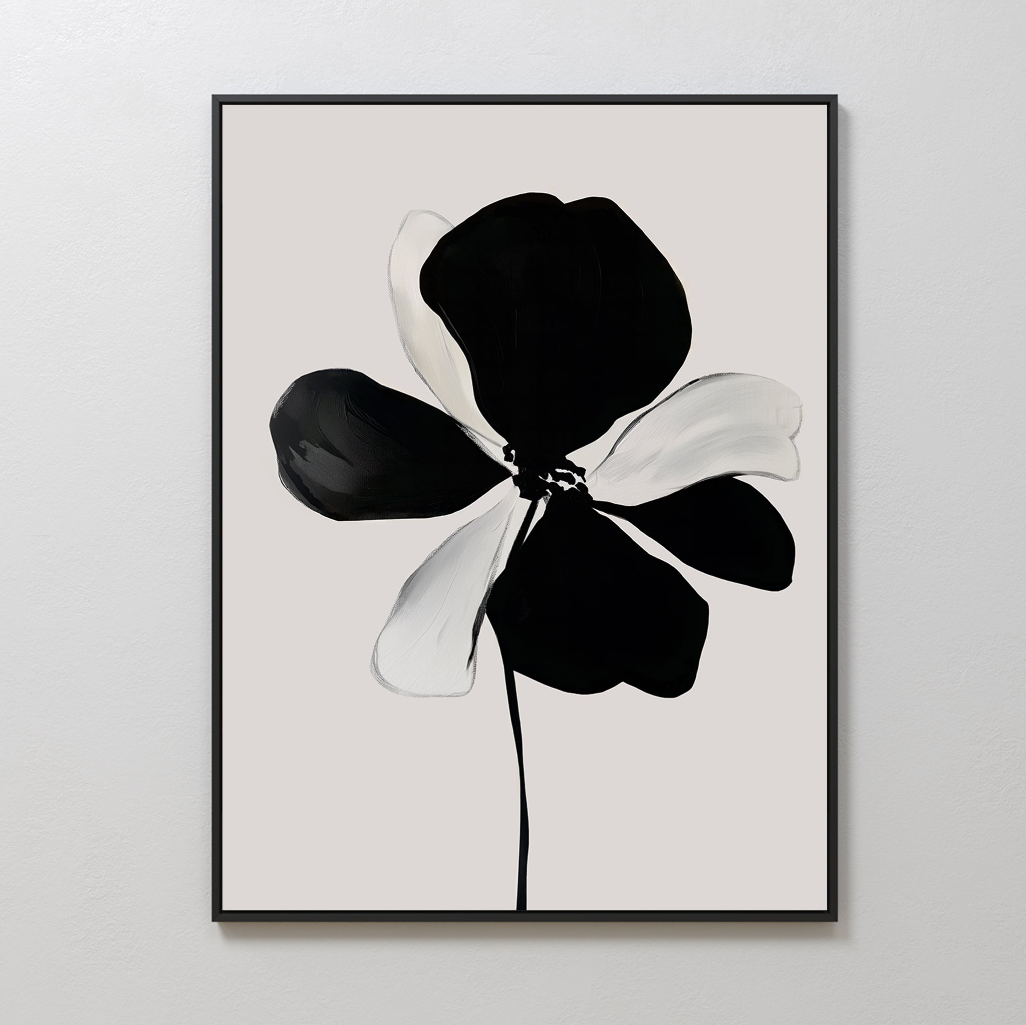 Monochrome Flora Abstract Canvas Art features a flower with five bold black and white petals on a light gray background, framed in a slim black frame and displayed on a plain white wall.