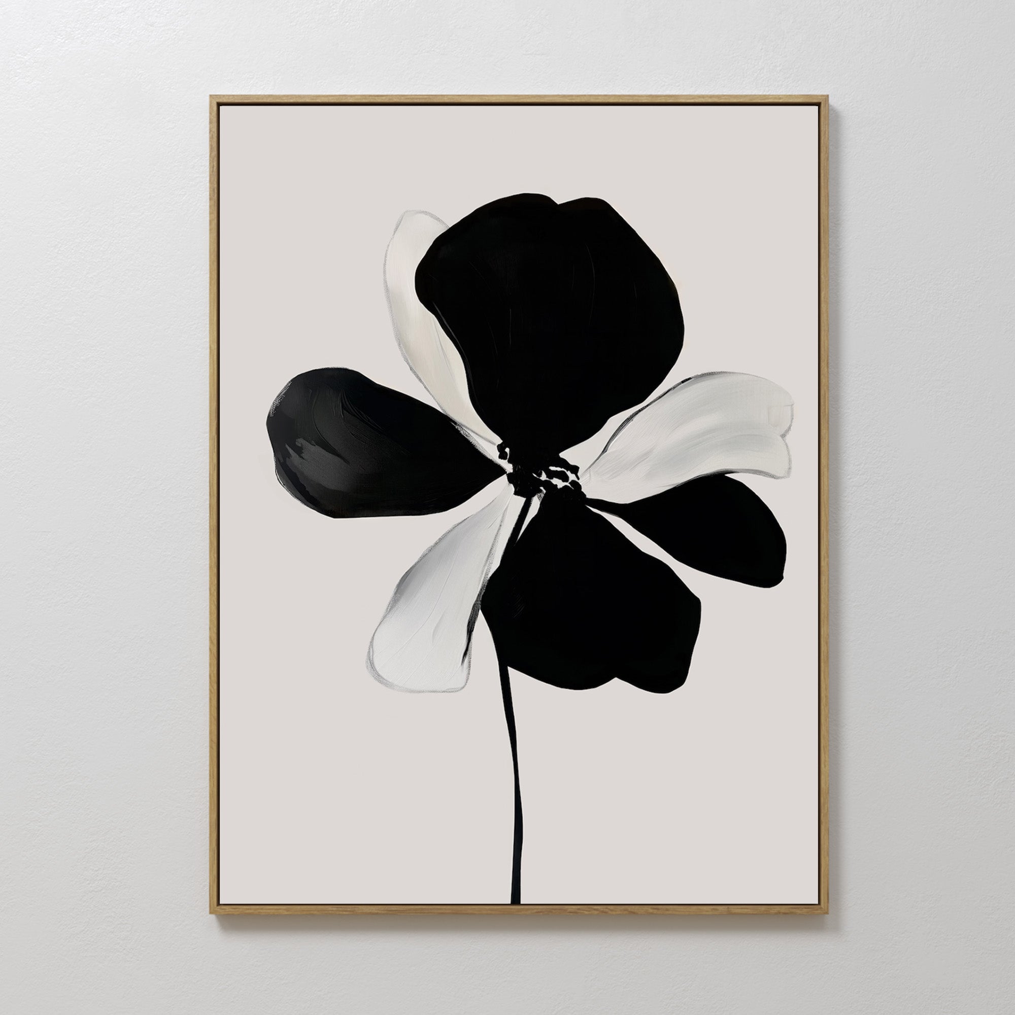 Monochrome Flora Abstract Canvas Art features a black and white floral print with large petals on a light gray background, framed in a slim gold frame. Its minimalist, abstract style makes it a striking decorative piece for any space.