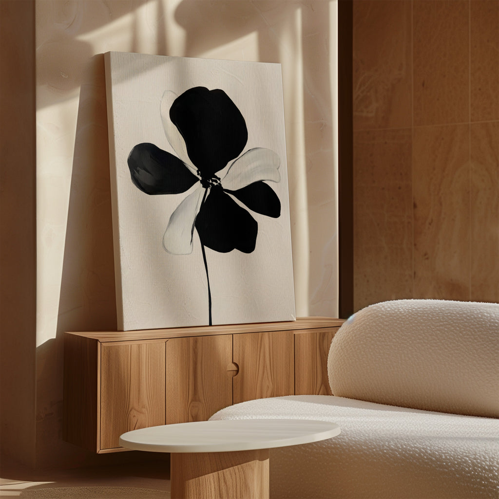 The Monochrome Flora Abstract Canvas Art hangs above a wooden cabinet, paired with a white textured sofa and round table in a softly lit, modern space.