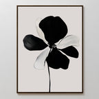 The Monochrome Flora Abstract Canvas Art features a single bold black and white flower with striking brushstrokes on a light gray background, framed in a slim dark frame for a simple, modern touch.