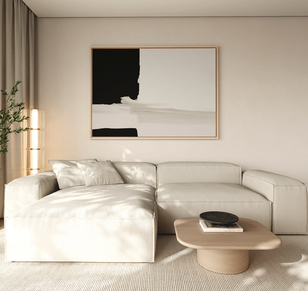 Minimalist living room with a light beige sectional sofa, low wooden coffee table with a black bowl, Monochrome Harmony Canvas Art – Horizontal on the wall, soft natural light, and a potted plant in the corner.