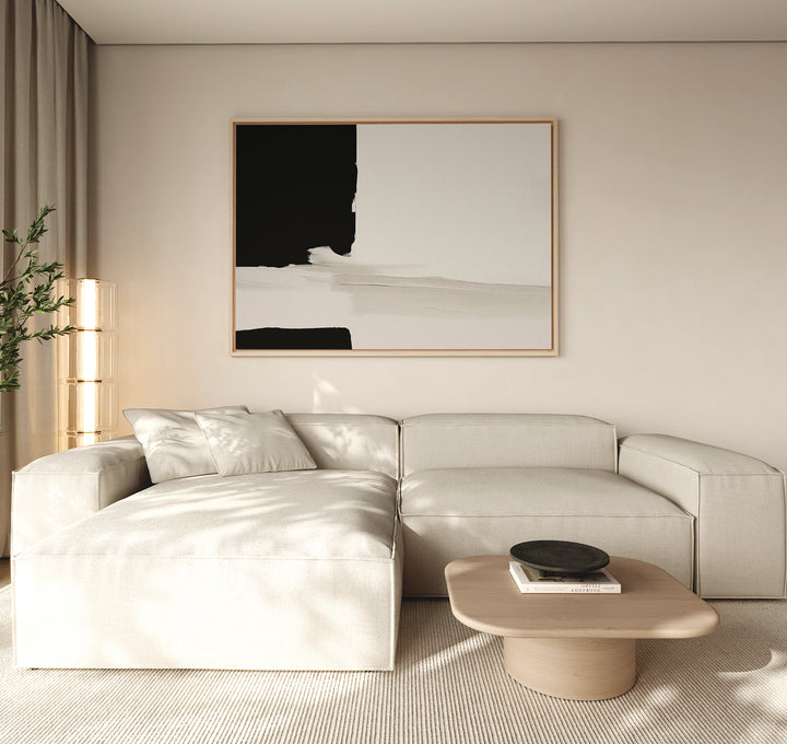 Minimalist living room with a light beige sectional sofa, low wooden coffee table with a black bowl, Monochrome Harmony Canvas Art – Horizontal on the wall, soft natural light, and a potted plant in the corner.