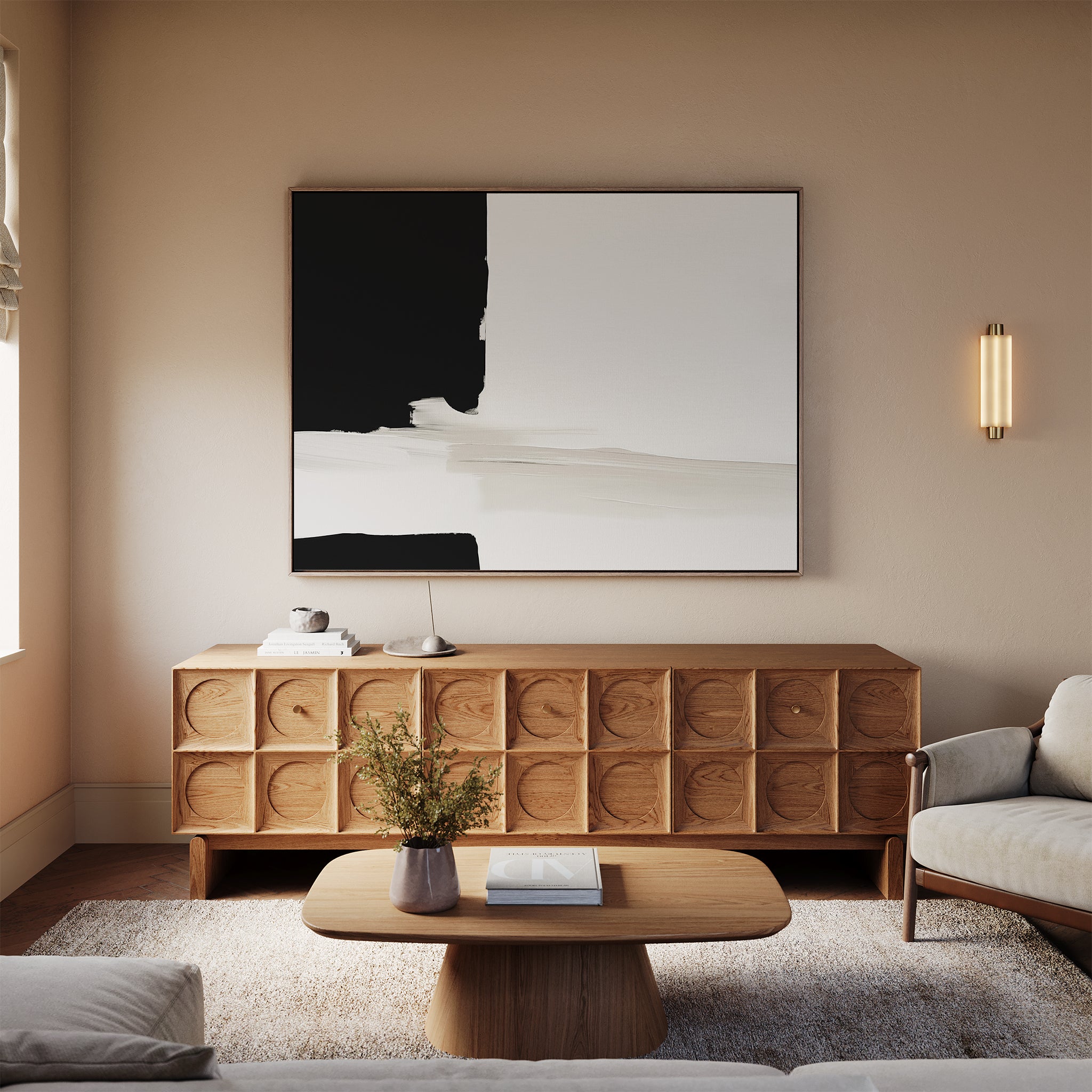 A modern living room with beige walls, a sculpted wooden sideboard, the Monochrome Harmony Canvas Art – Horizontal in black and white, a wooden coffee table, light sofas, a vase with flowers, and soft natural light.