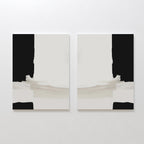 The Monochrome Harmony Set of 2, featuring minimalist wall art with black vertical edges, white centers, and beige horizontal brushstrokes at the bottom, is displayed side by side on a white wall.