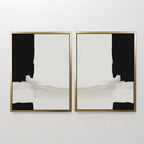 The Monochrome Harmony Set of 2 features minimalist wall art with bold black sides and central light beige and white brush strokes, displayed side by side on a white wall in stylish frames.