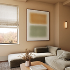 A modern living room in neutral tones features a green velvet sectional, a wooden coffee table with dried flowers, and the Morning Whisper Canvas Art above the window dressed with beige Roman shades.