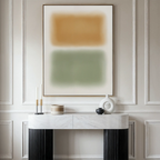 A minimalist console table with decorative objects stands beneath the Morning Whisper Canvas Art, featuring soft tan and green blocks, set against an elegant white paneled wall.