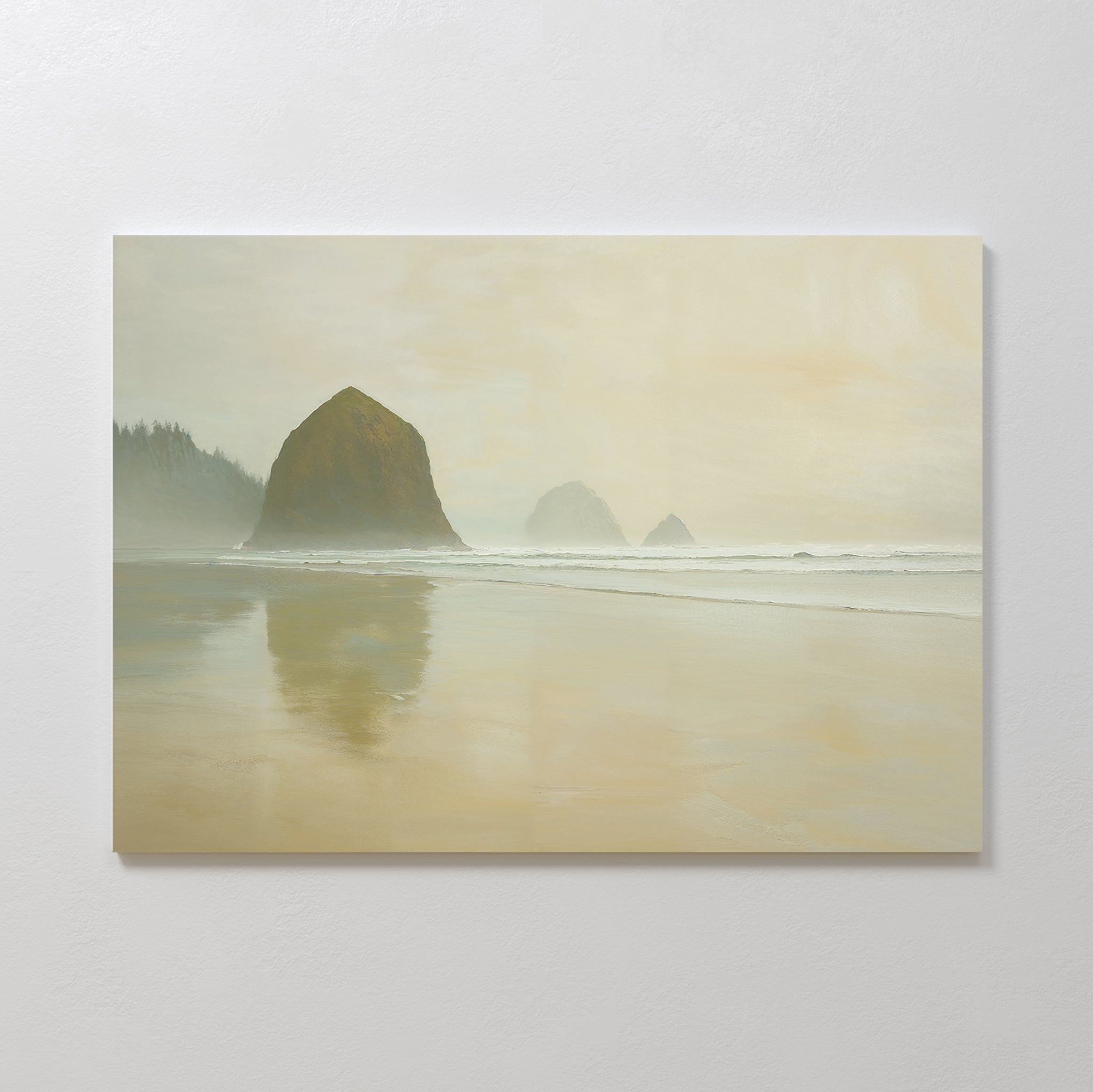 The Morning At Cannon Beach Canvas Art captures the coastal mood with misty rock formations reflected on wet sand under an overcast sky and distant trees along the shoreline.