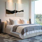 Modern bedroom featuring a large beige bed with white and gray bedding, accented by the Mountain Contour Set of 2 prints above the headboard. Tall decorative vases flank the bed and large windows fill the space with natural light.