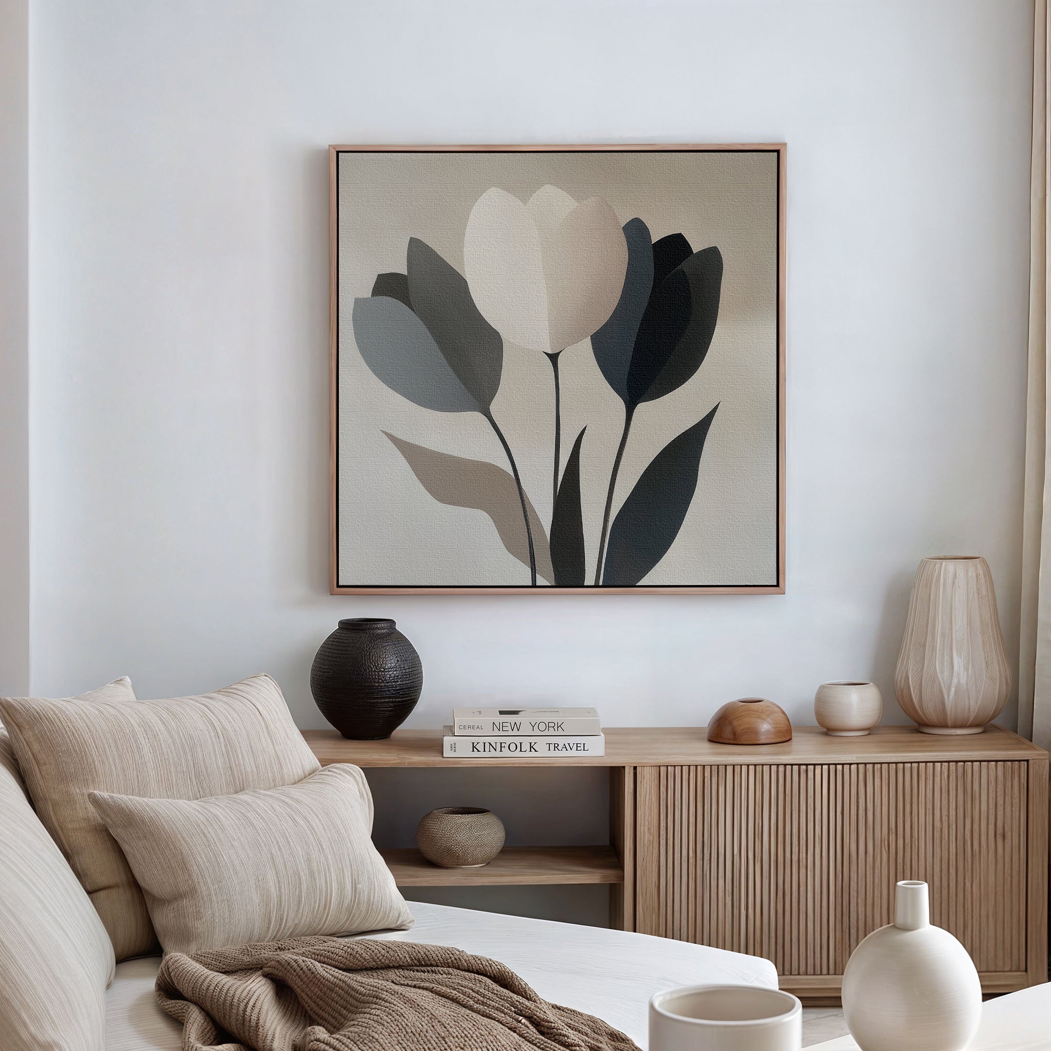 A minimalist living room with a neutral-toned sofa, beige and white cushions, a wooden sideboard, decorative vases, books, and the Muted Elegance Canvas Art framed on the white wall. Natural light filters in from the right.