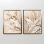 The Natural Texture Set of 2 features framed abstract paintings with soft cream and beige shapes, resembling petals or leaves, creating elegant neutral wall art when displayed side by side on a light-colored wall.