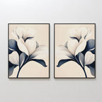 The Navy Magnolia Set of 2 features minimalist framed prints of white magnolia flowers with dark blue and gray leaves, displayed side by side. This floral wall art adds a soft, modern, and elegant touch to any space.