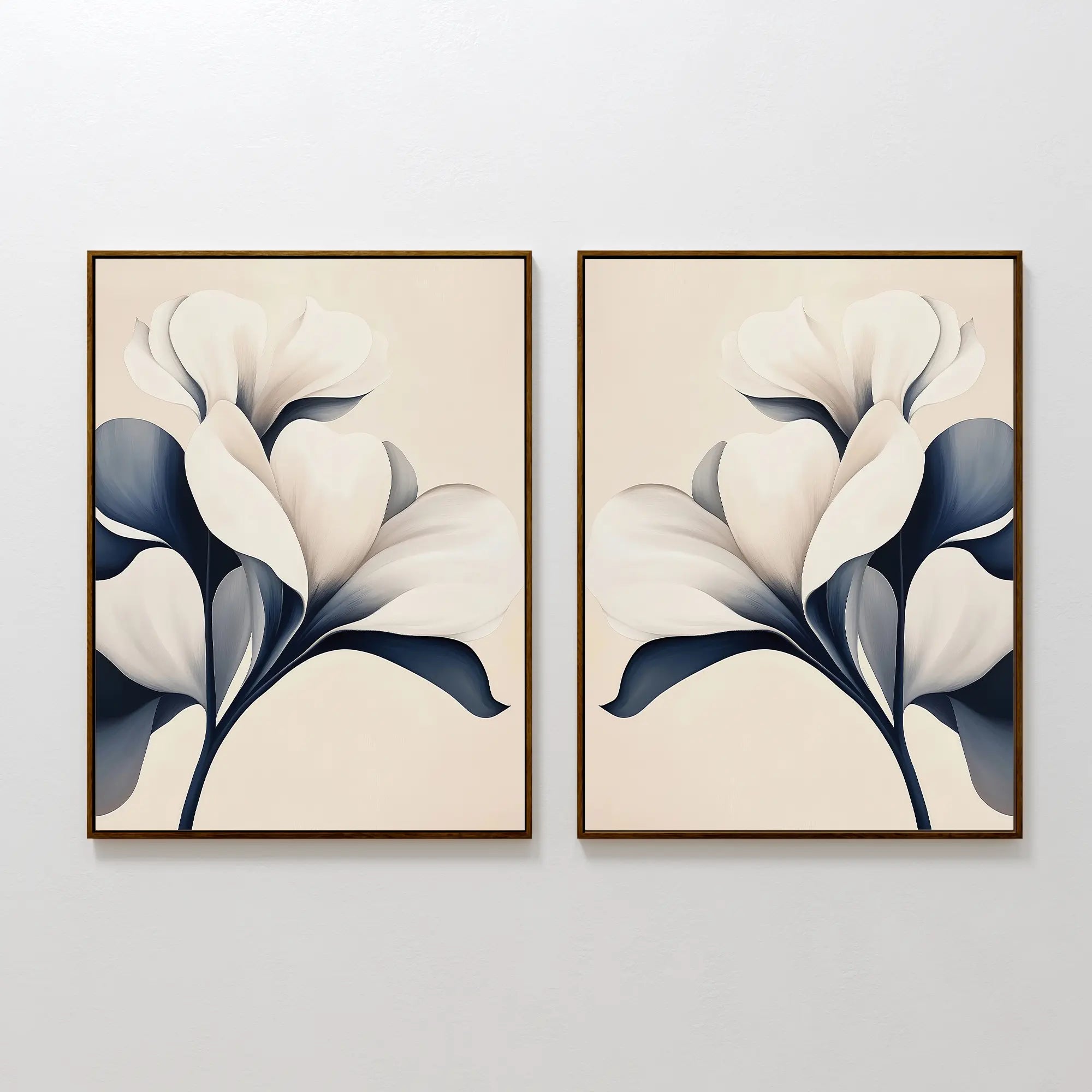 The Navy Magnolia Set of 2 features framed prints of abstract white magnolia flowers with dark blue leaves on light beige backgrounds, creating modern, nearly identical floral wall art for stylish side-by-side display.