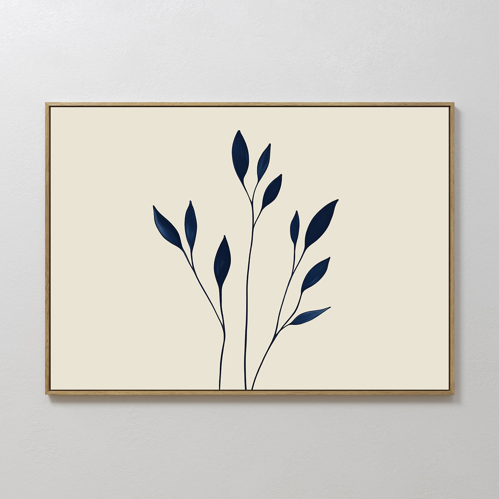 Navy Stem Canvas Art features thin black stems with solid navy blue leaves on a beige background, framed in slim wood and displayed on a white wall for striking, modern minimalist decor.
