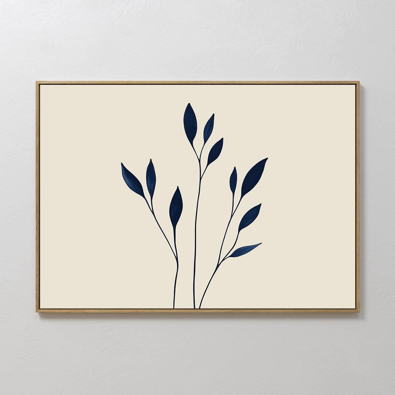 Navy Stem Canvas Art features thin black stems with solid navy blue leaves on a beige background, framed in slim wood and displayed on a white wall for striking, modern minimalist decor.