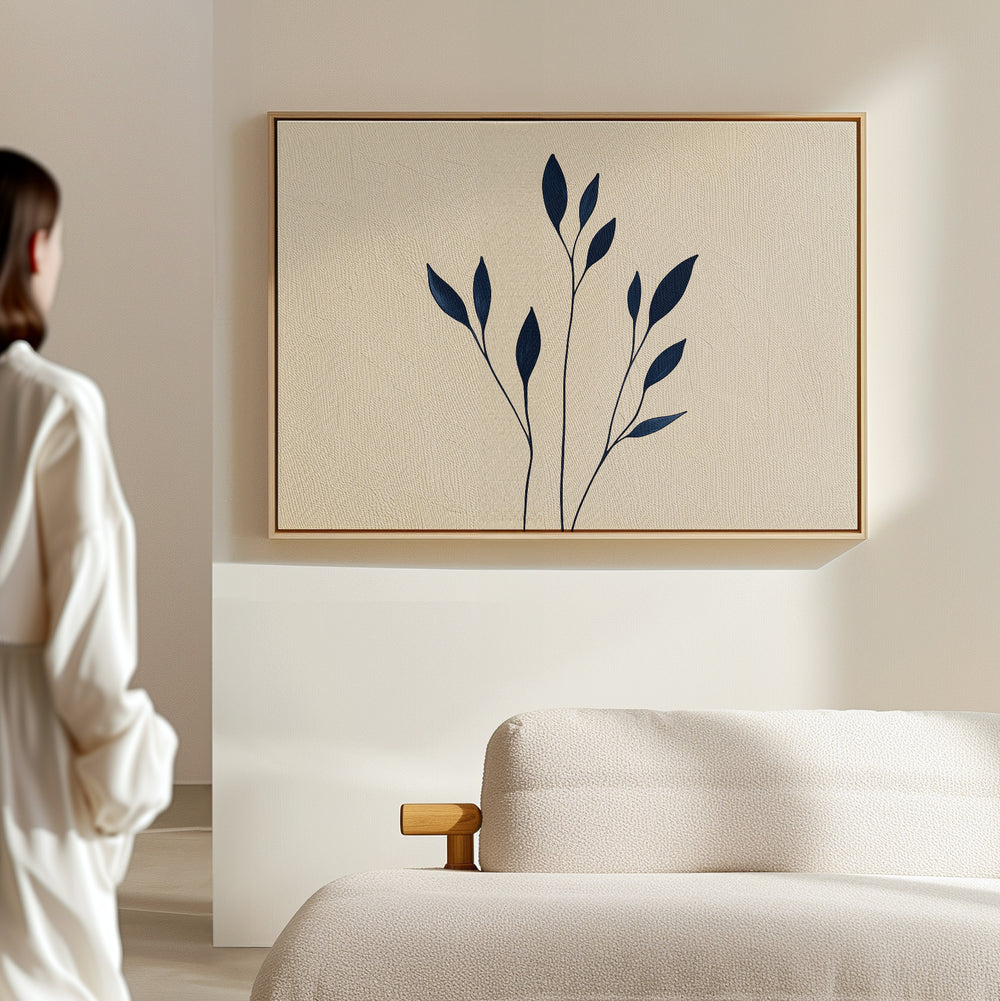 A person stands in a bright, minimal room facing a beige wall, where the Navy Stem Canvas Art with bold dark blue shapes is displayed above a cream-colored sofa.