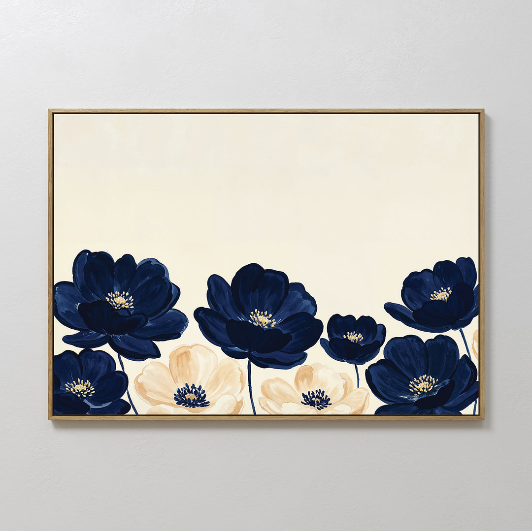 The Nightshade Canvas Art – Horizontal features large navy blue and cream flowers with dark centers on a light beige background, beautifully framed and displayed on a white wall.