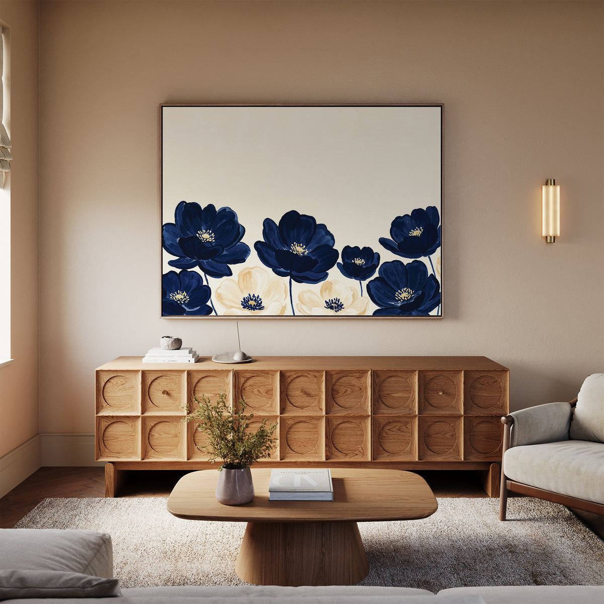 A modern living room with light beige walls, wooden furniture, a beige sofa, and a wooden coffee table. Above the sideboard hangs the Nightshade Canvas Art – Horizontal, featuring bold blue and white floral designs.