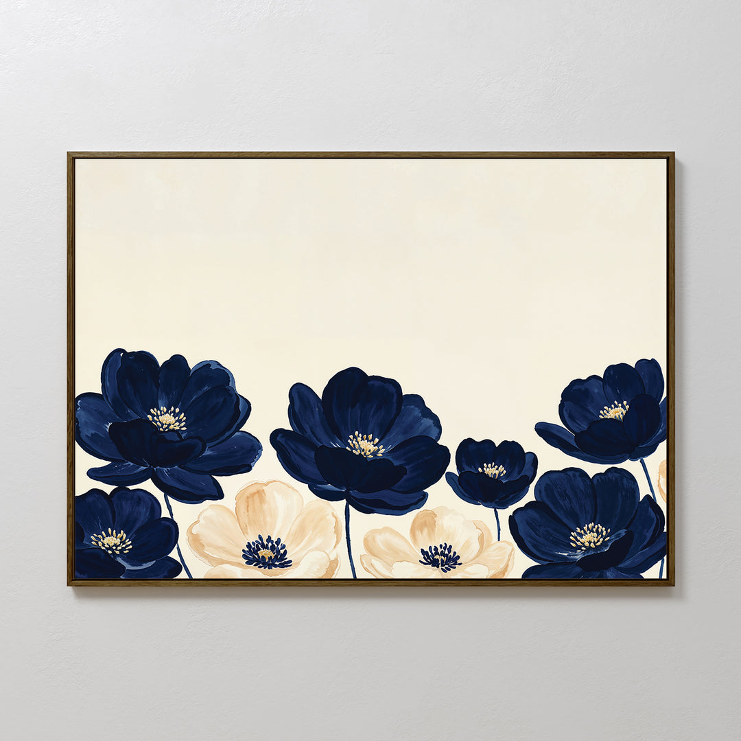 The Nightshade Canvas Art – Horizontal features large navy blue and cream flowers with yellow centers on a light beige background, beautifully framed and displayed against a plain white wall.