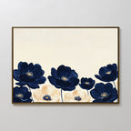 The Nightshade Canvas Art – Horizontal features large navy blue and cream flowers with yellow centers on a light beige background, beautifully framed and displayed against a plain white wall.
