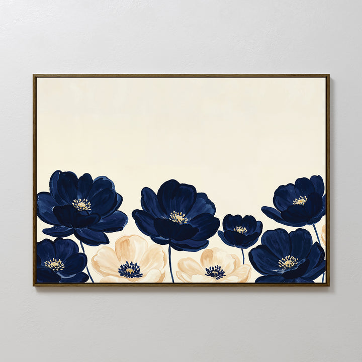 The Nightshade Canvas Art – Horizontal features large navy blue and cream flowers with yellow centers on a light beige background, beautifully framed and displayed against a plain white wall.